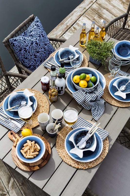 http://pioneerlinens.com/cdn/shop/articles/a-stylish-and-simple-nautical-bridal-shower-setting-with-an-uncovered-table-wicker-chargers-blue-and-fish-plates-plus-a-citrus-centerpiece_1024x1024.jpg?v=1597696283